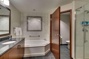 Un bagno moderno con vasca, due lavandini, box doccia in vetro e un water.