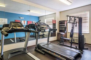 Una palestra con tapis roulant, macchinari per pesi e attrezzature per esercizi.