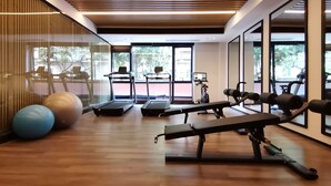 A gym with treadmills, exercise balls, and weight machines.