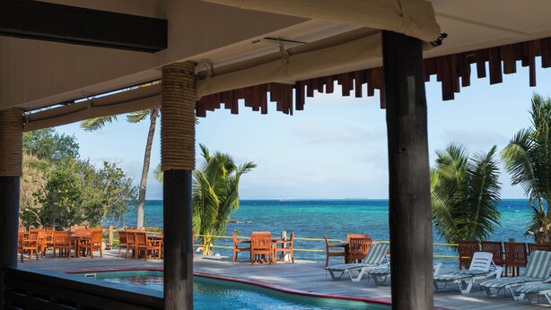 A wooden deck with lounge chairs and a pool, overlooking the ocean. - Funky Fish Beach Resort (Malolo Island)