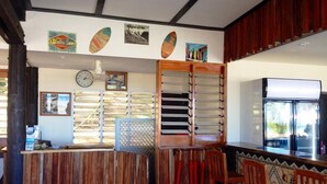 A bar area with wooden furniture, a clock, and various wall decorations. - Funky Fish Beach Resort (Malolo Island)