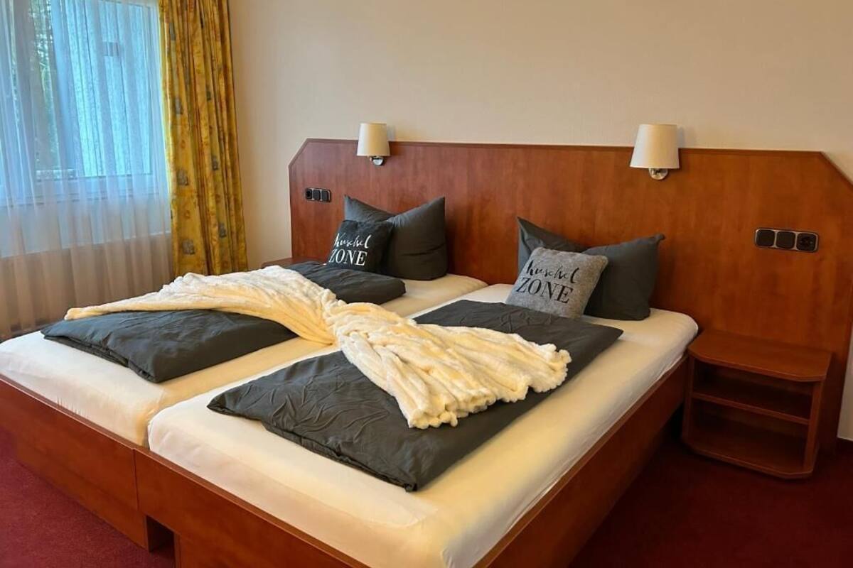 Habitación cuádruple clásica, 2 camas matrimoniales, se aceptan mascotas, vista al jardín | Escritorio, espacio para trabajar con laptop y cortinas blackout