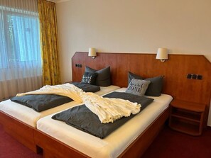 Habitación cuádruple clásica, 2 camas matrimoniales, se aceptan mascotas, vista al jardín | Escritorio, espacio para trabajar con laptop y cortinas blackout