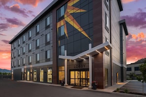 A modern hotel with a prominent lobby entrance, large windows, and a star-shaped design on the facade. - La Quinta Inn & Suites By Wyndham Kelowna Bc (Kelowna)
