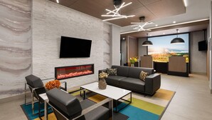 A modern living room with a fireplace, a flat-screen TV, a sofa, and a coffee table. - La Quinta Inn & Suites By Wyndham Kelowna Bc (Kelowna)