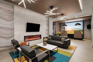 Una sala de estar moderna con chimenea, un televisor de pantalla plana, un sofá y una mesa de centro.