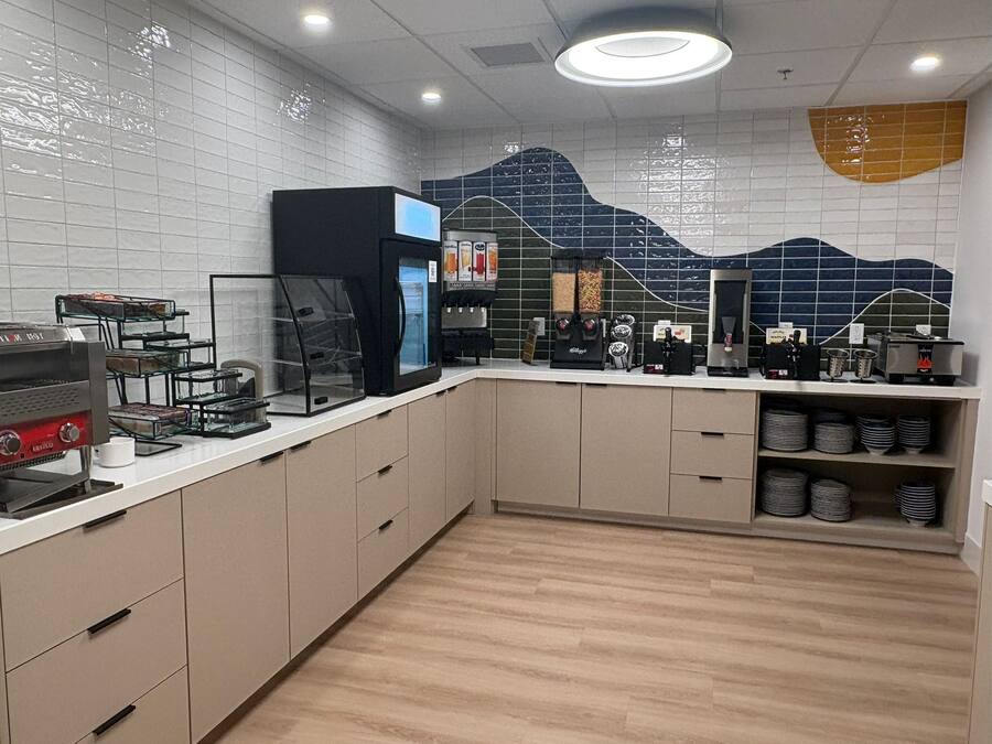A modern kitchen with a white countertop, stainless steel appliances, and a tiled backsplash.