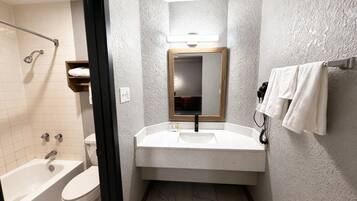 A bathroom with a bathtub, toilet, sink, and a towel rack.