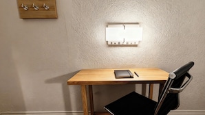 Un bureau en bois, une chaise noire, un carnet et un stylo.