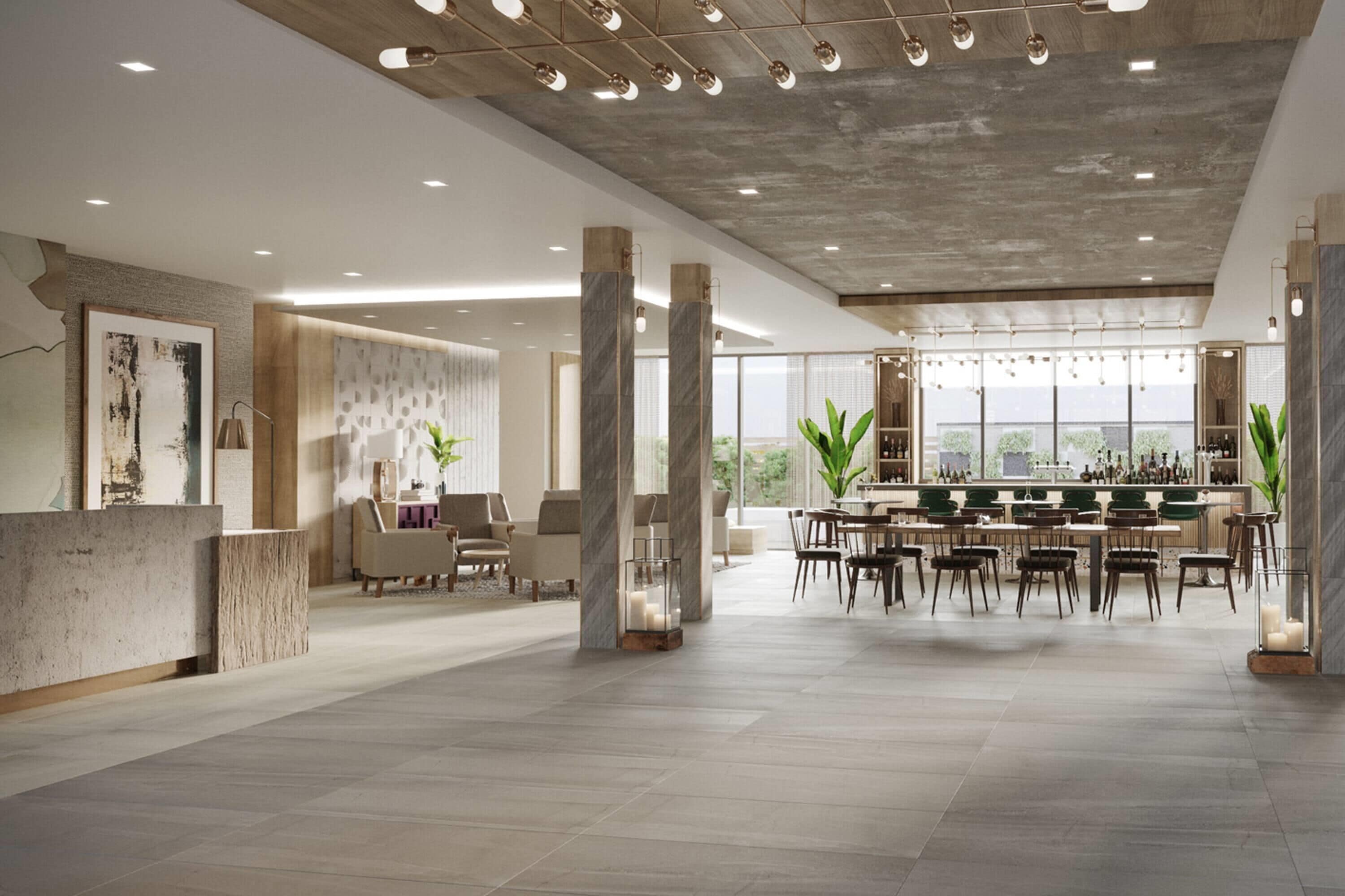 A spacious hotel lobby with a bar area, seating arrangements, and large windows providing views.