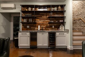 A kitchen with white cabinets, a built-in oven, and a brick wall.