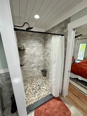 A bathroom with a shower, a tiled floor, and a visible shower curtain. - Rough River Lake - 5BR Waterfront Home - Sleeps 15 - Firepit (Westview)