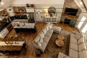 A spacious living area with a large sectional sofa, a dining table with chairs, and a kitchen with modern appliances.