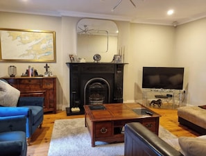 A living room with a fireplace, a television, and a coffee table.