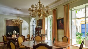 A formal dining room with a round table, chairs, and a chandelier. - Waou Palacio Tenorio Santa Cruz IX (Sevilla)