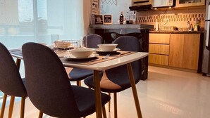 A modern kitchen with wooden cabinets, a microwave, and a dining area with a table and chairs.