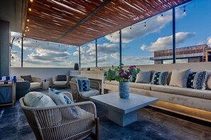 An outdoor seating area with wicker furniture, a sofa, and a coffee table.