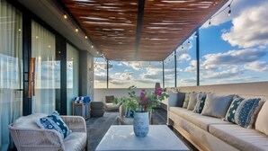 A rooftop terrace with a modern design, featuring a sofa, a chair, a coffee table, and a potted plant. - 🌿 Jungle Penthouse w/ Private Pool | 4 Min to Beach + Town (Tulum)