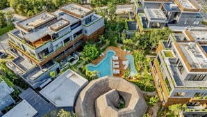 A modern residential complex with multiple buildings, a central spiral staircase, and a swimming pool. - 🌿 Jungle Penthouse w/ Private Pool | 4 Min to Beach + Town (Tulum)