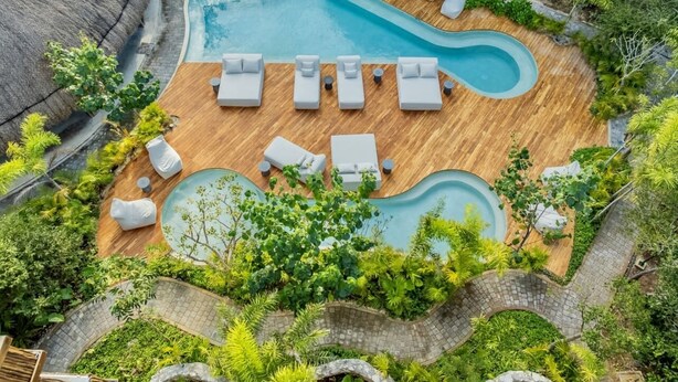 An aerial view of a pool area with a wooden deck, lounge chairs, and surrounding greenery. - 🌿 Jungle Penthouse w/ Private Pool | 4 Min to Beach + Town (Tulum)