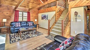 A log cabin interior with a living room, a staircase, and a fireplace. - Gather and Celebrate · Poconos Escape (Pleasant Mount)