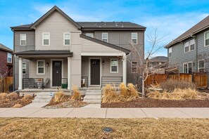 A two-story residential building with a front porch, a visible mailbox, and a well-maintained lawn. - Modern Spacious TownHome in Central Park (Aurora)