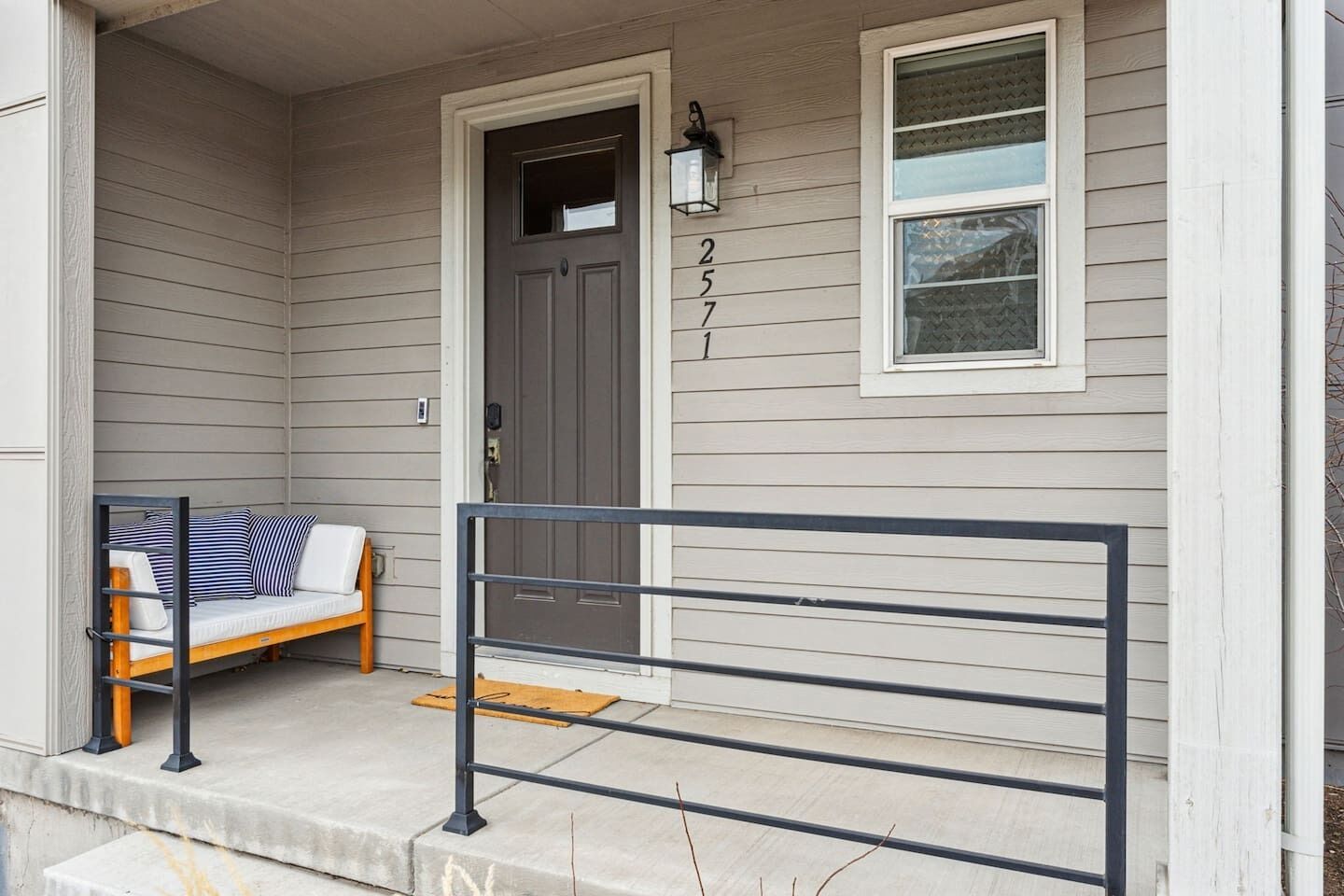A house with a porch, a bench, a door, and a window.