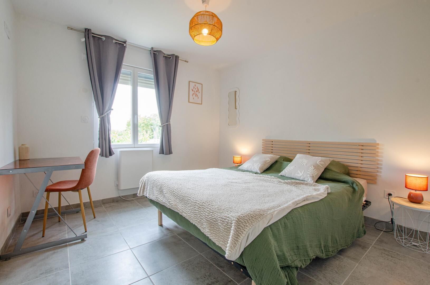 A bedroom with a bed, a desk, and a chair.