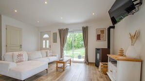 Ein Wohnzimmer mit einer Couch, einem Couchtisch, einem Fernseher und einem Kamin.