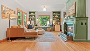 A living room with a fireplace, a sofa, a coffee table, and a bookshelf. - Luxury home in North End Boise (Boise)