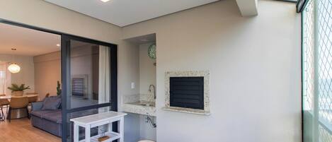 Un espacio habitable compacto con comedor, kitchenette y vistas a través de un ventanal.