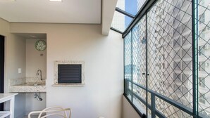 A modern bathroom with a sink, mirror, and window overlooking a cityscape.