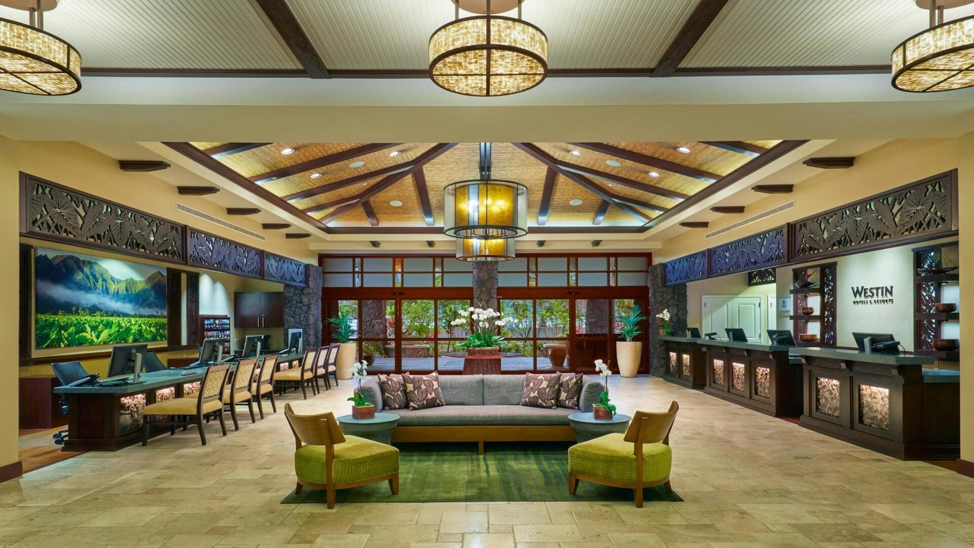 A spacious lobby with a high ceiling, a central seating area, and a reception desk.