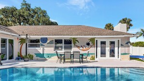 Ein Poolbereich mit Hängematte, Terrassenmöbeln und Blick auf den Pool.