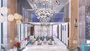 A spacious lobby with a modern chandelier, seating area, and a reception desk. - Canvas Hotel (Da Nang)
