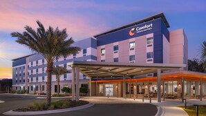 Un hotel Comfort Inn & Suites con un diseño moderno, que cuenta con una entrada cubierta y un área de estar al aire libre.