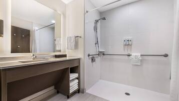 Un bagno moderno con doccia, lavandino e specchio.