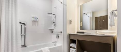 A modern bathroom with a bathtub, shower, and vanity.