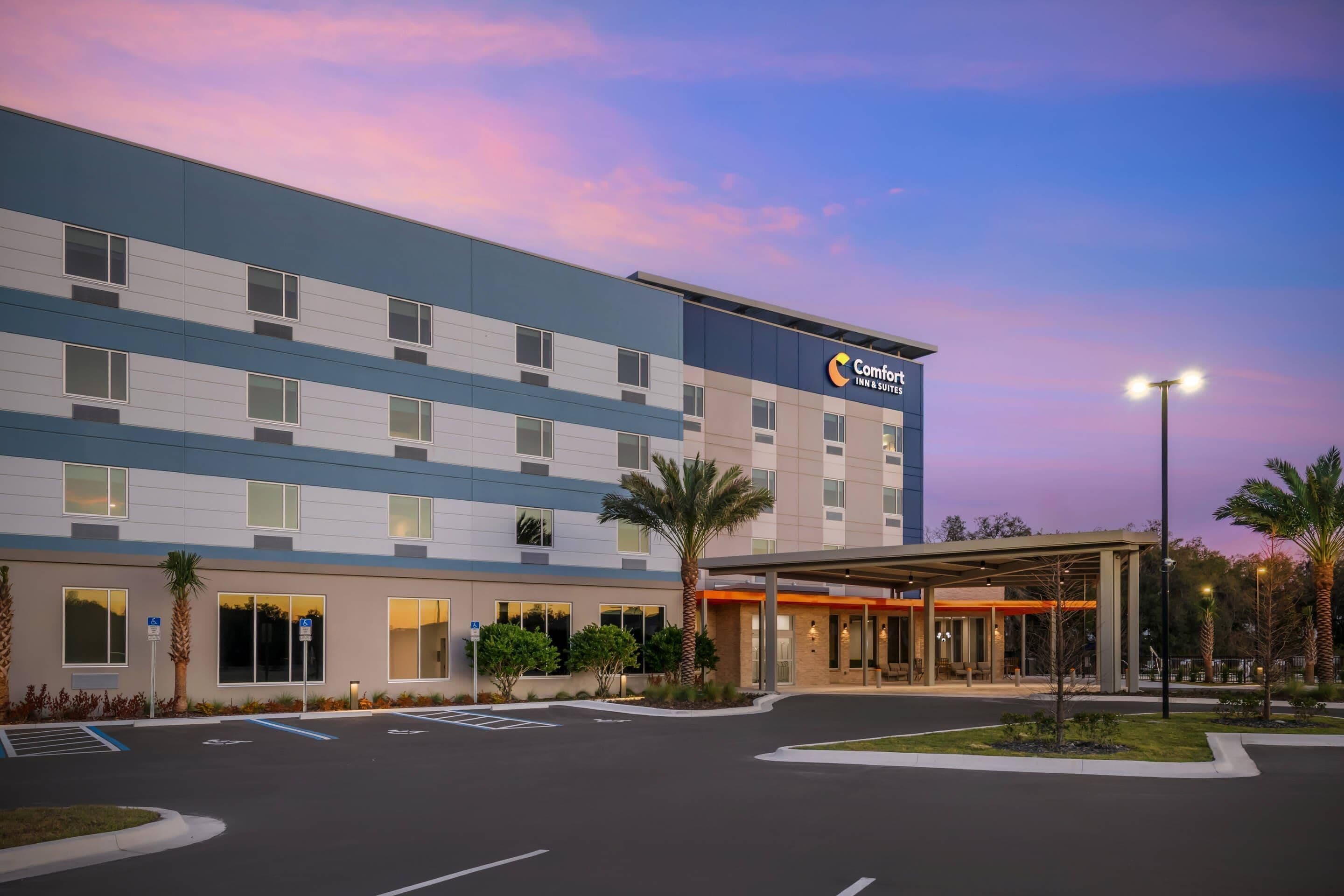 A Comfort Inn & Suites hotel with a modern design, featuring a covered entrance and a parking lot.
