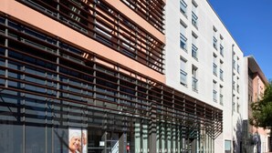 A modern building with a glass facade and a series of horizontal beams. - Quality Aparthotel Chalon-sur-Saône Gare (Chalon-sur-Saone)