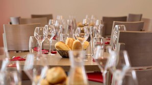 A dining table set with multiple wine glasses and a basket of bread. - Quality Aparthotel Chalon-sur-Saône Gare (Chalon-sur-Saone)