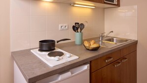Una cocina con estufa, pileta y alacenas.