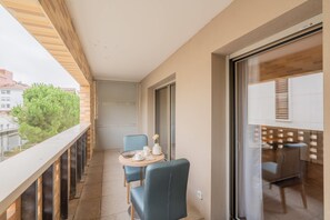 Ein Balkon mit Tisch, Stühlen und Blick auf die Stadt.