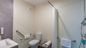 A bathroom with a toilet, a sink, a shower, and a towel rack. - Quality Aparthotel Mulhouse (Mulhouse)