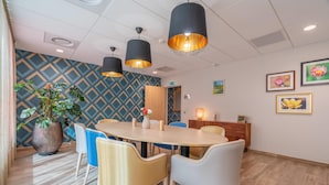 Un comedor moderno con una mesa de madera, sillas e iluminación colgante.