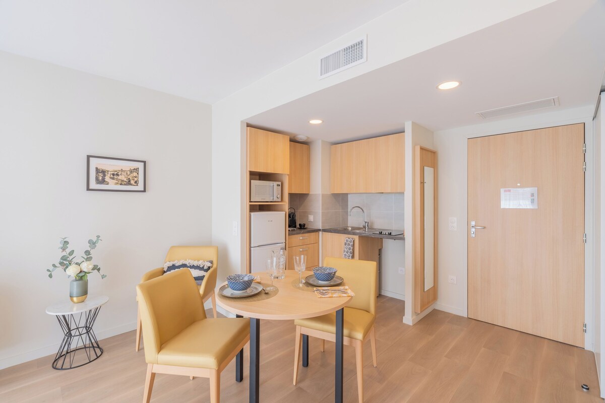 A compact living space with a dining area, kitchenette, and a door with a sign.