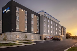 A modern hotel with a stone facade and multiple windows. - Everhome Suites Bowling Green by Choice Hotels (Bowling Green)