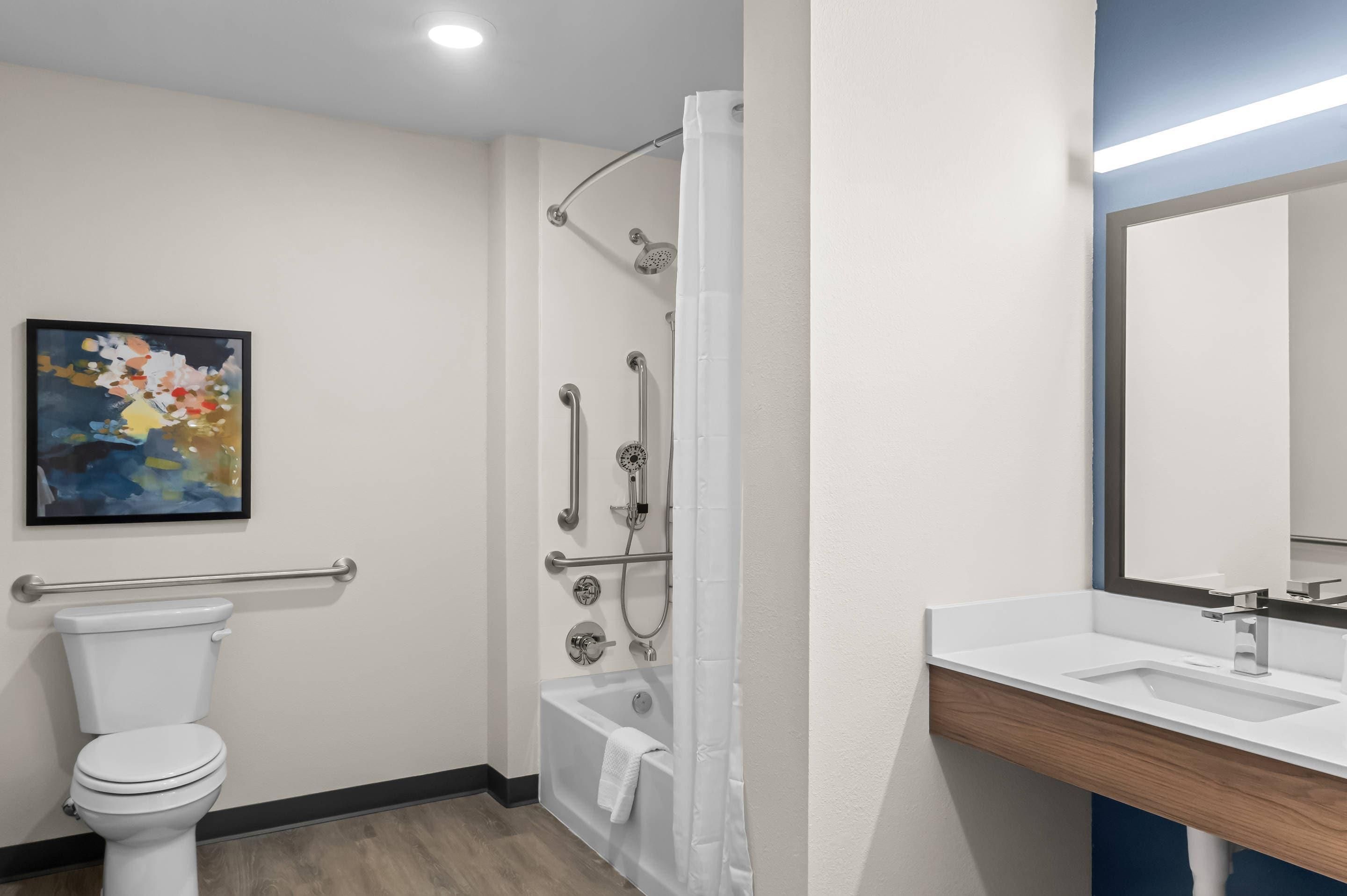 A modern bathroom with a toilet, shower, and sink.