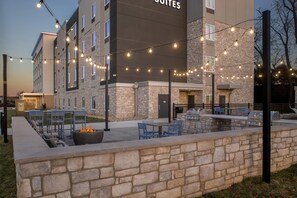 A hotel exterior with outdoor seating, a fire pit, and string lights. - Everhome Suites Bowling Green by Choice Hotels (Bowling Green)