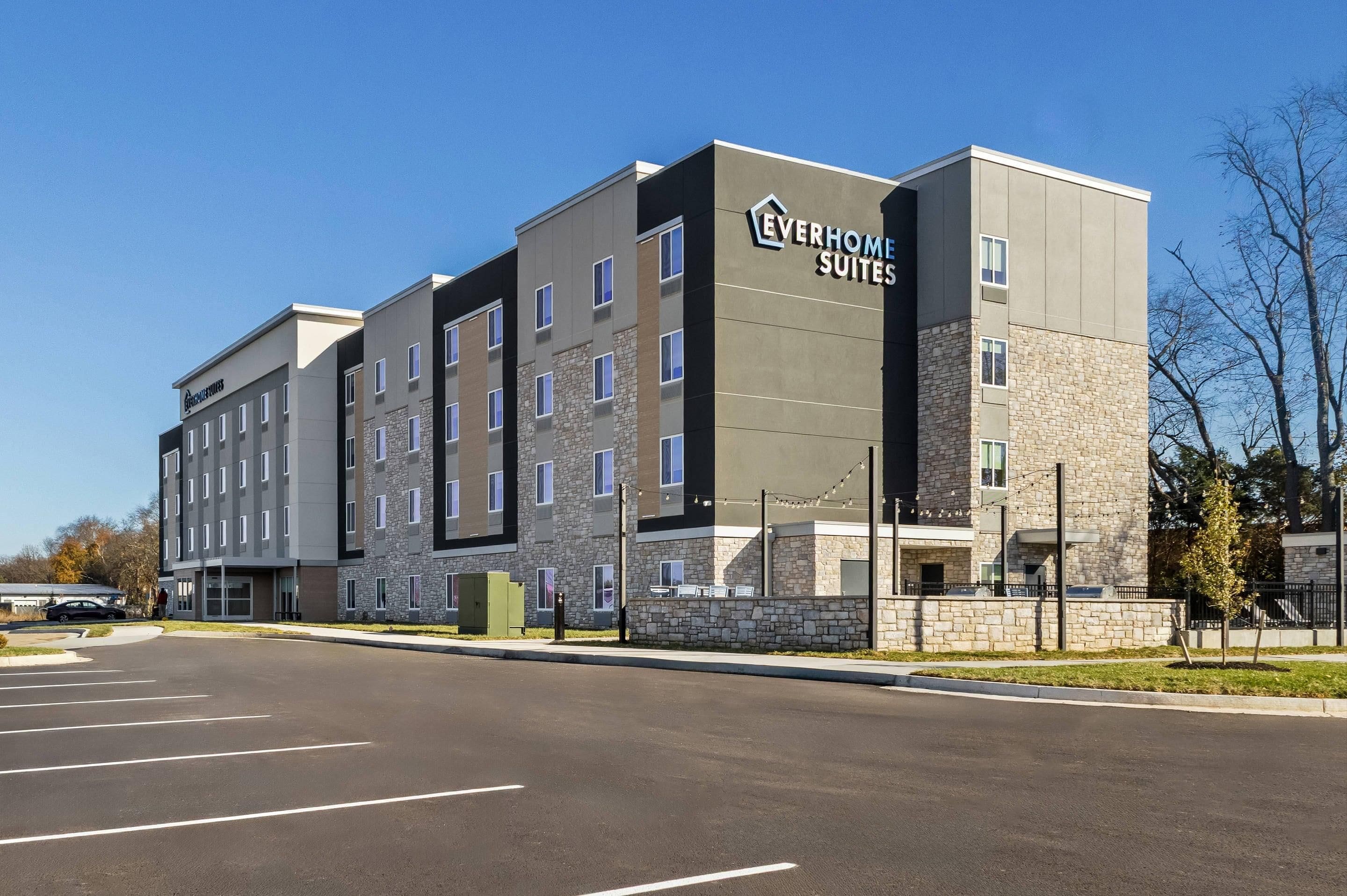 Un hôtel moderne à plusieurs étages, doté d’une façade en pierre et offrant une vue sur un ciel dégagé.